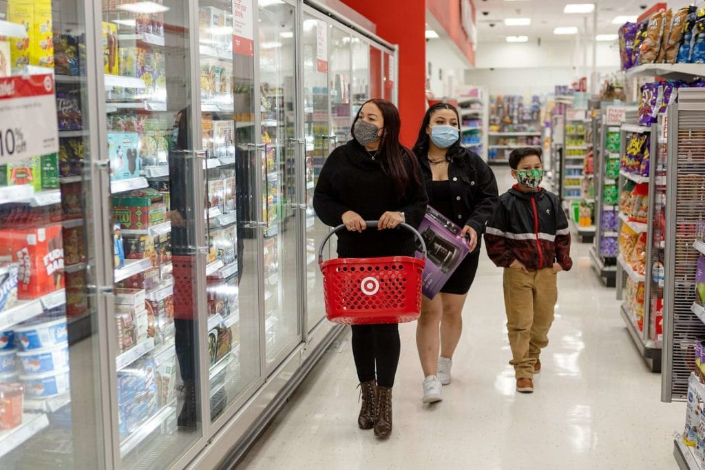 Victoria Vega (left) and her children, Alondra Vega (16), and Bryant Aleman (8), wear face masks as they shop at Target on Thursday, February 4, 2021, in San Francisco, Calif.