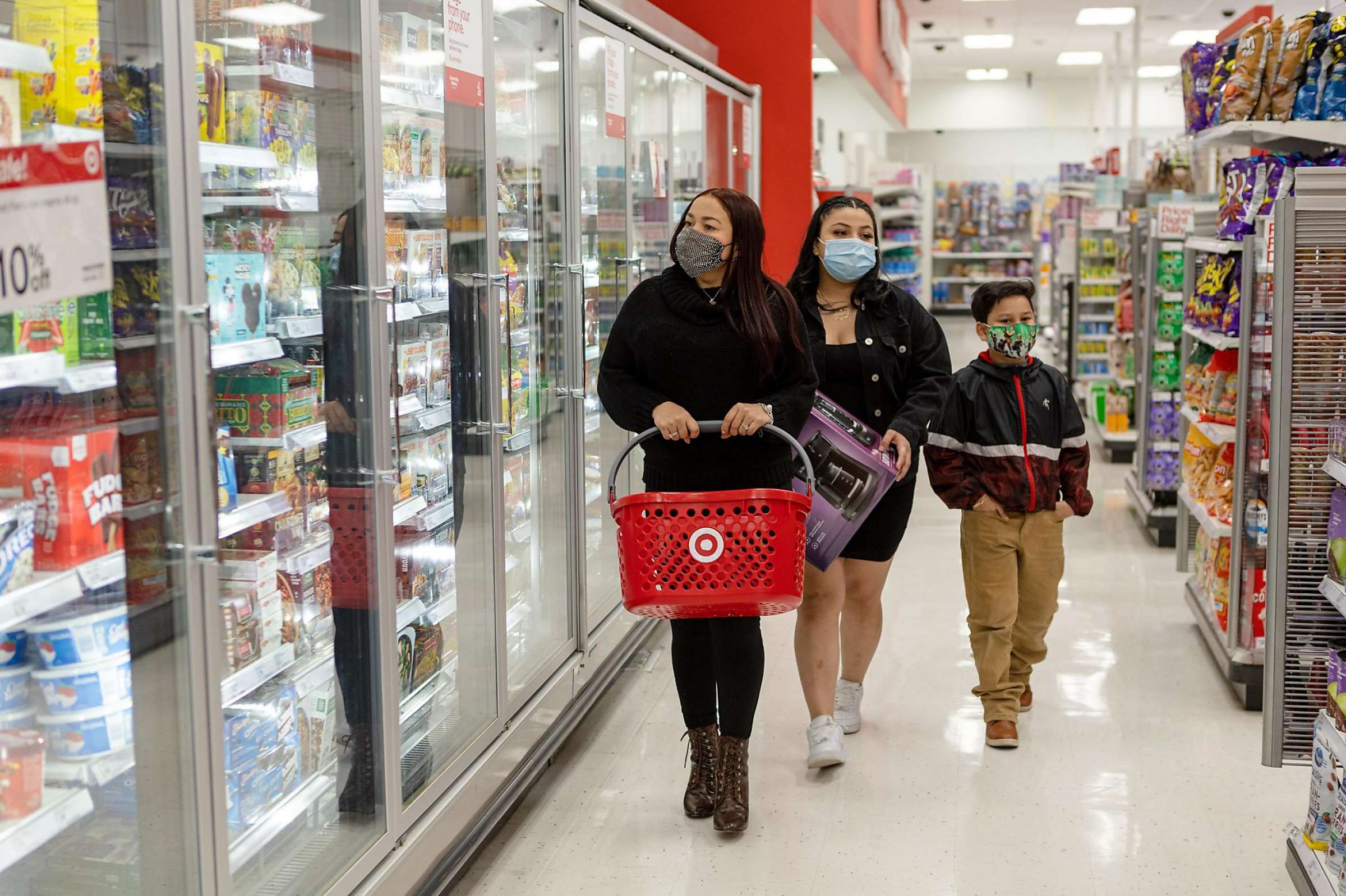 Victoria Vega (left) and her children, Alondra Vega (16), and Bryant Aleman (8), wear face masks as they shop at Target on Thursday, February 4, 2021, in San Francisco, Calif.