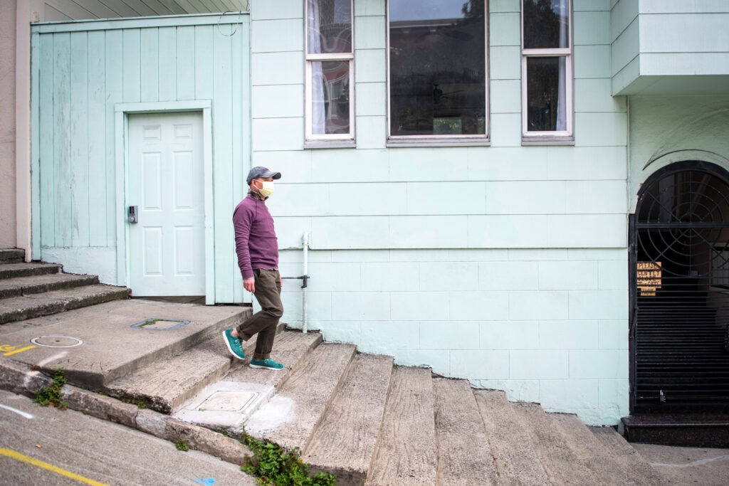 Henry Zhang, a middle-aged immigrant from Taishan, China walks down a set of stone steps in San Francisco’s Chinatown neighborhood.