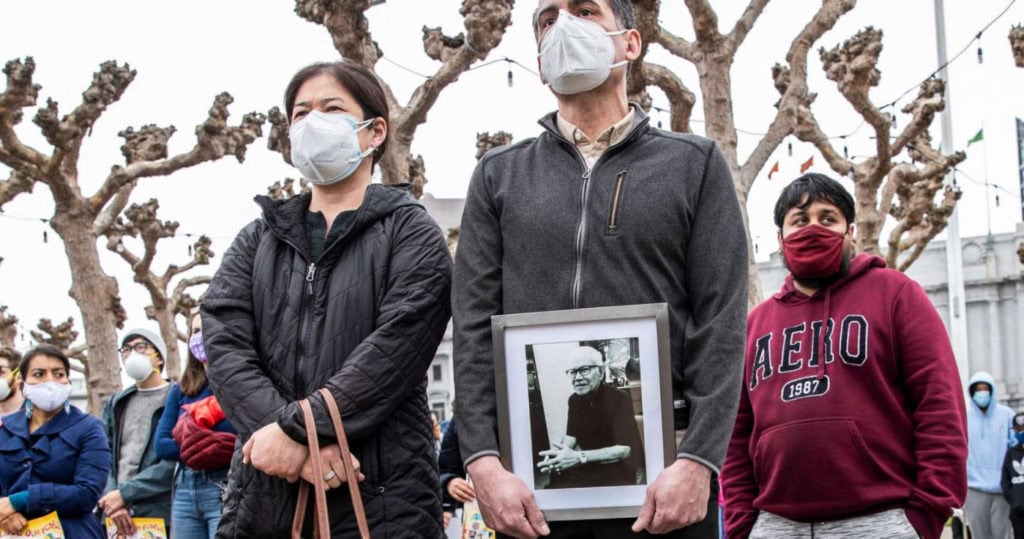 Vicha Ratanapakdee, 84, was assaulted on Jan. 28 while out on a morning walk and later died from head injuries. His son-in-law, Eric Lawson (right), holds a photo of Ratanapakdee as he stands with his wife, Monthanus, while attending a rally on Feb. 14 at San Francisco’s Civic Center Plaza in condemnation of the recent increase in violence towards the Asian American community around the Bay Area.