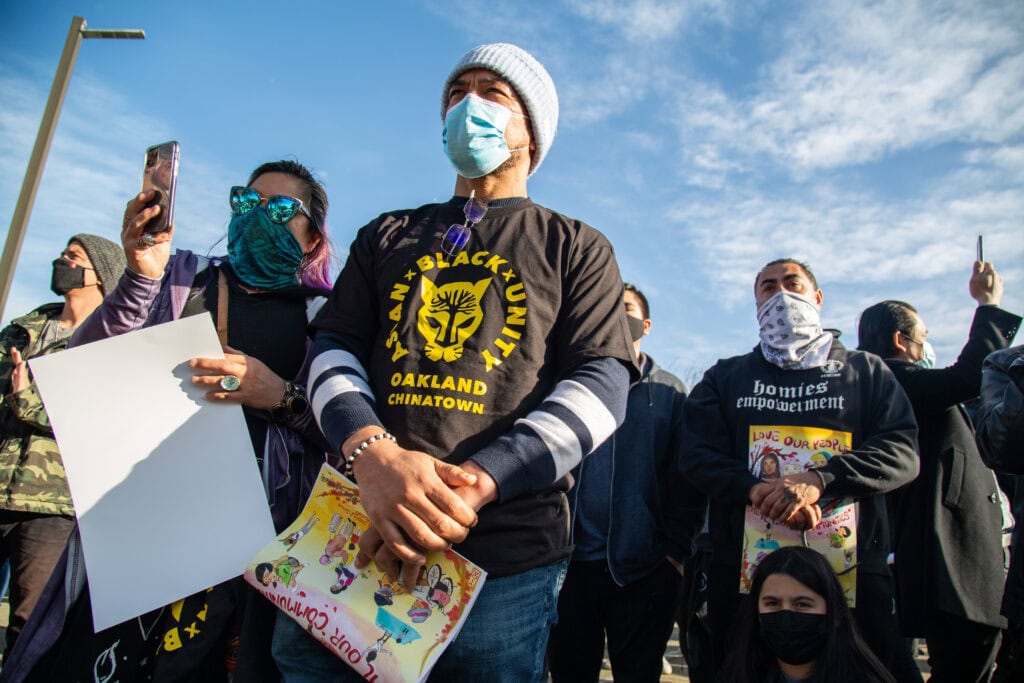 Protestors wearing t-shirts calling for Black and Asian unity attend the Oakland Day of Action in February 2021.