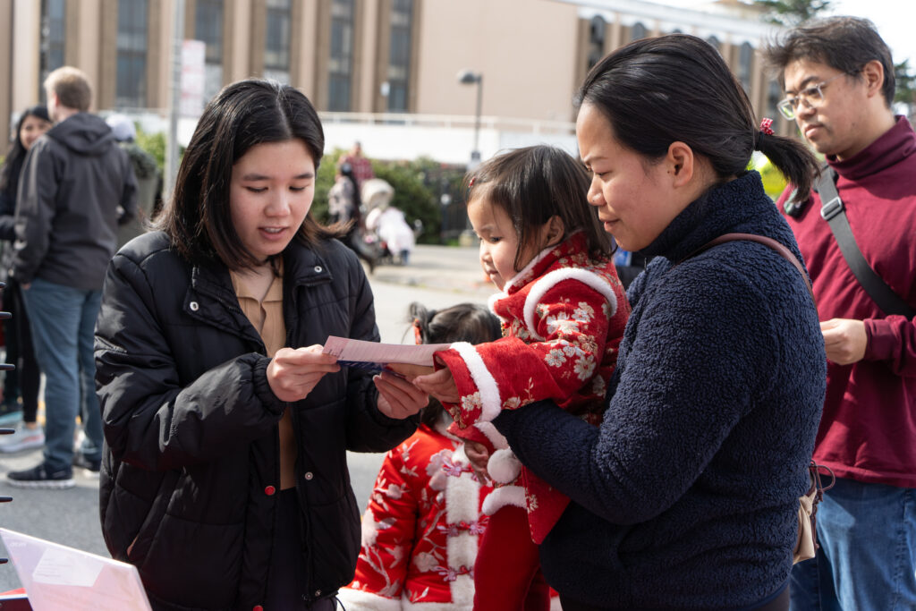 Xiaojun Jung at Lunar New Year Festival speaking with a community member.