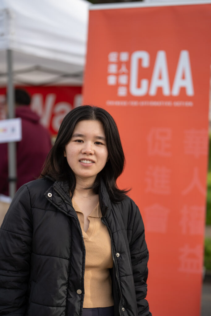 Xiaojun Jiang in front of CAA banner